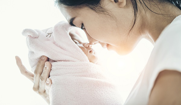 The newborn baby sleeping in the hands of the mother and the nos The newborn baby sleeping in the hands of the mother and the nos